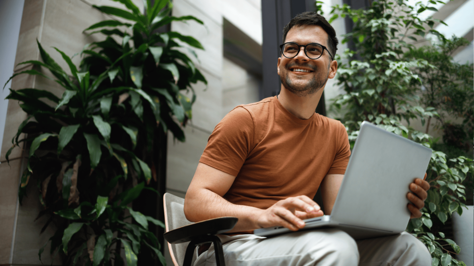 Erfolgreicher Unternehmer vor Pflanzenhintergrund im modernen Office.